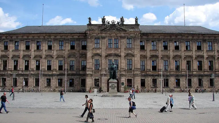 Barocke Westfassade des Erlanger Schlosses bei Tageslicht, dahinter blauer Himmel