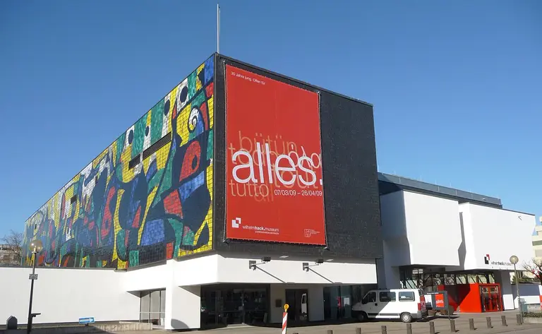 Außenansicht des Wilhelm-Hack-Museums in Ludwigshafen am Rhein mit der markanten farbigen Keramikwand von Joan Miró an der Gebäudefassade.