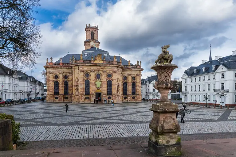 Barocke Ludwigskirche in Saarbrücken mit heller Sandsteinfassade und Turm vor blauem Himmel