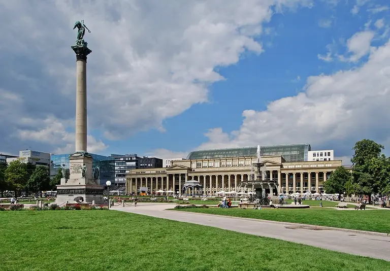 Das barocke Neue Schloss am Schlossplatz in Stuttgart mit Springbrunnen und Jubiläumssäule unter blauem Himmel